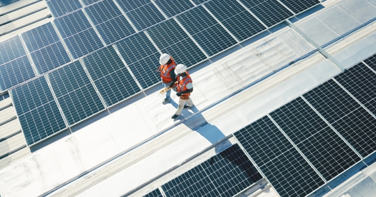 team walking on roof with solar panels